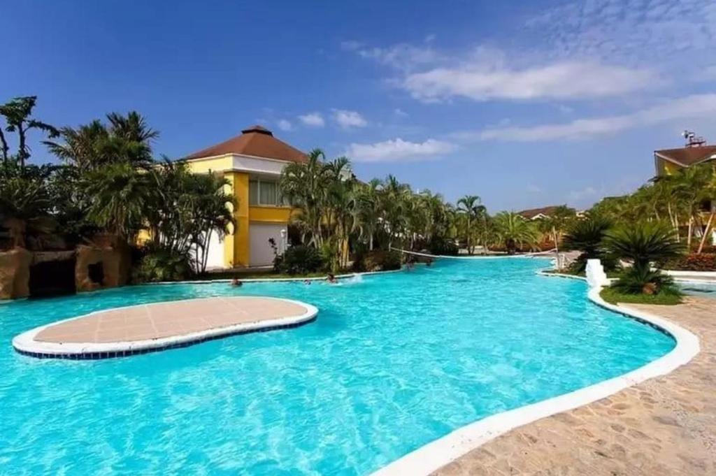 a swimming pool in front of a resort at Family Paradise in Palma Real in La Ceiba