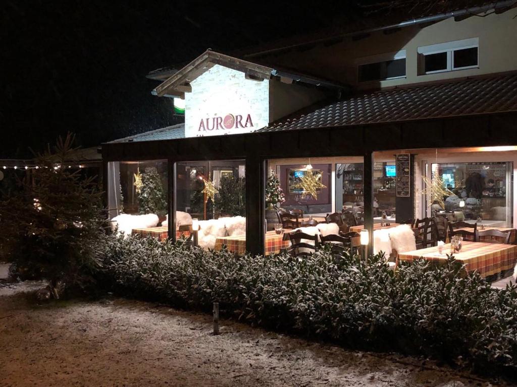 restauracja z kanapami i stołami w nocy w obiekcie Aurora Panzió w mieście Bük