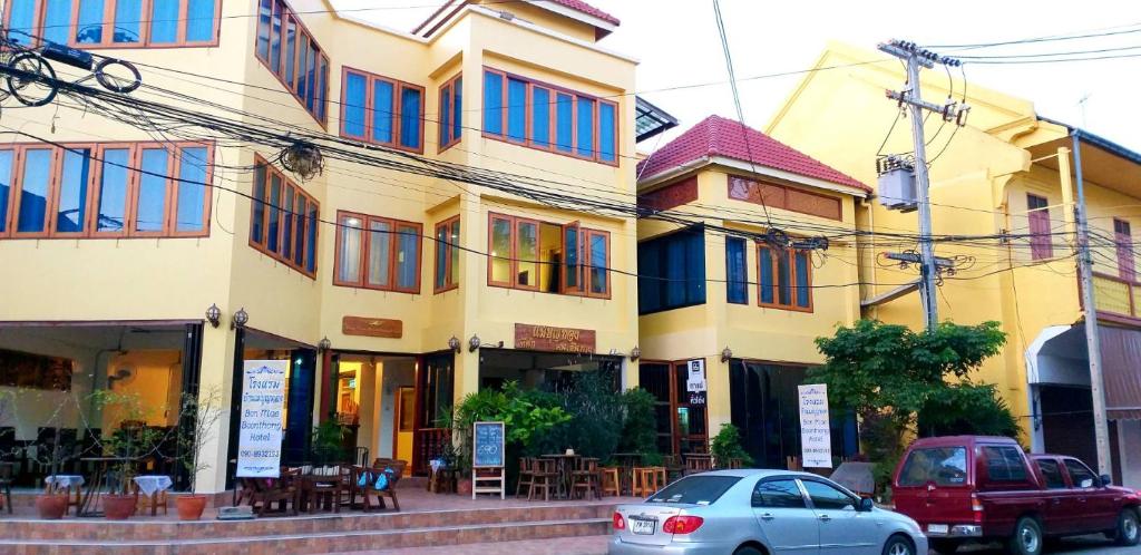 a building with cars parked in front of it at Ban Mae Boonthong in Lampang