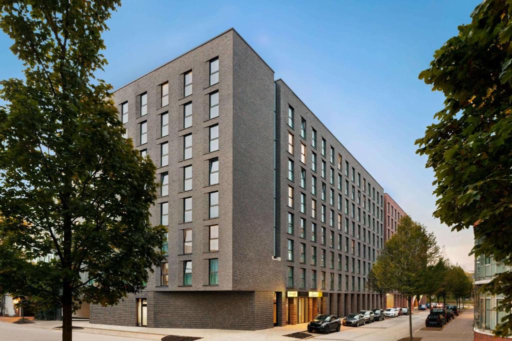 un edificio alto gris en una calle de la ciudad en Super 8 by Wyndham Hamburg Mitte, en Hamburgo