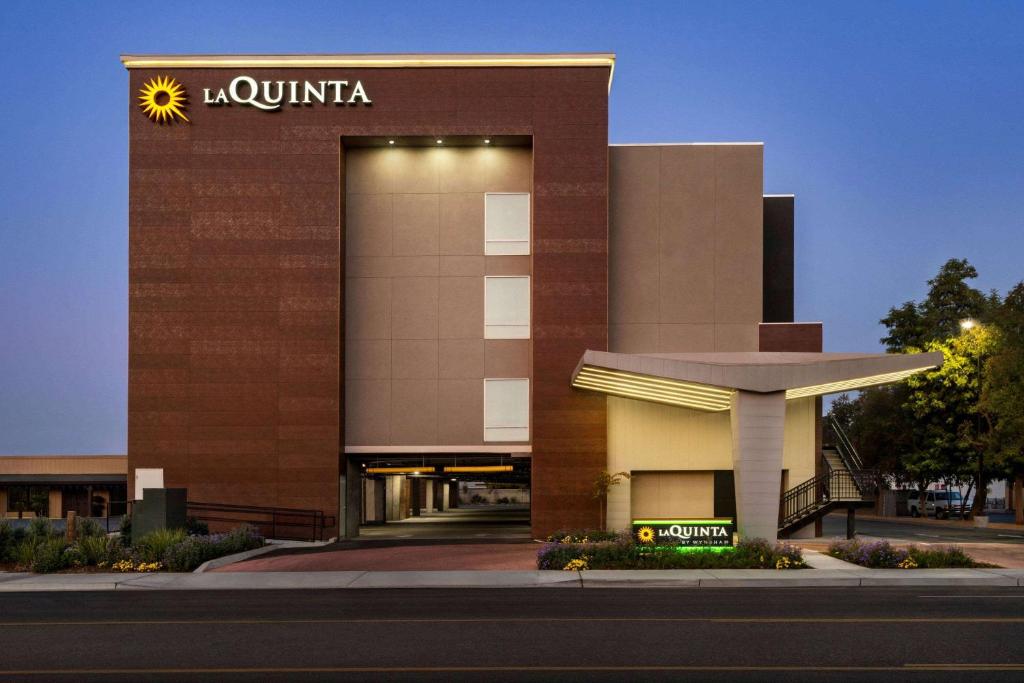 een hotel met een bord aan de zijkant van een gebouw bij La Quinta by Wyndham Clovis CA in Clovis