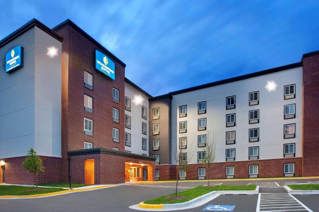 una imagen de un edificio de hotel con aparcamiento en WoodSpring Suites Washington DC Northeast Greenbelt, en Greenbelt