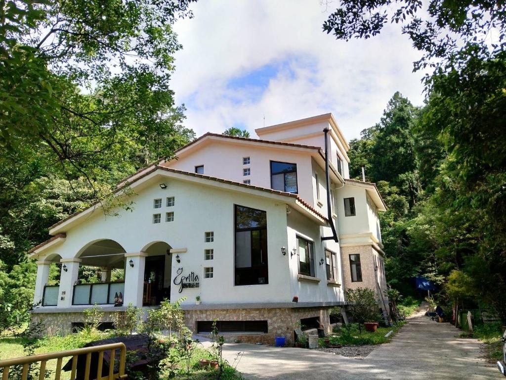 a white house with trees in front of it at Spring Villa in Nanzhuang