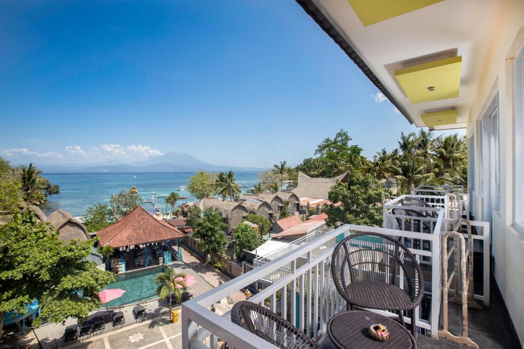 een balkon met uitzicht op de oceaan en een resort bij The Tanis Beach Resort Nusa Lembongan in Nusa Lembongan