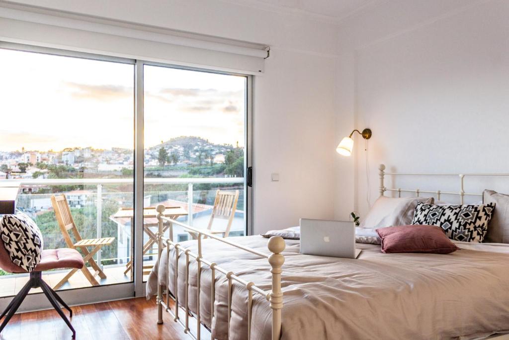 een slaapkamer met een bed met een laptop erop bij Pátio da Achada View Apartment in Funchal