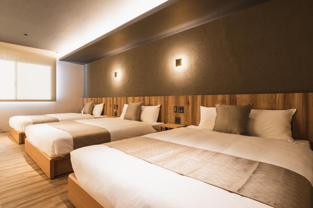 Postel nebo postele na pokoji v ubytování GRAND BASE Beppu Ekihigashi