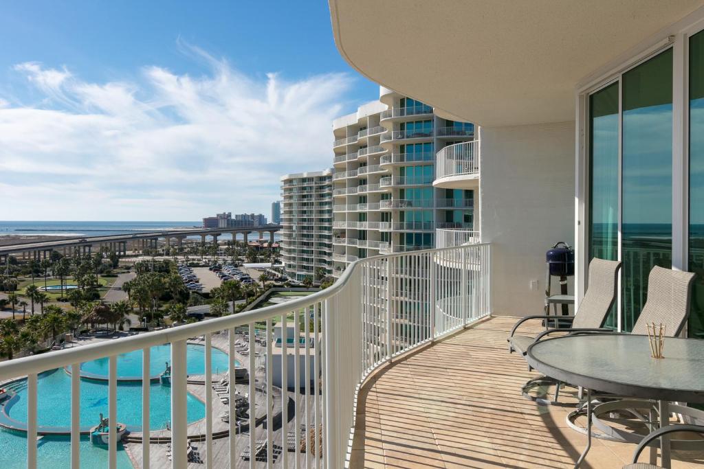 a balcony with a table and chairs and a view of the ocean at Caribe Resort in Orange Beach
