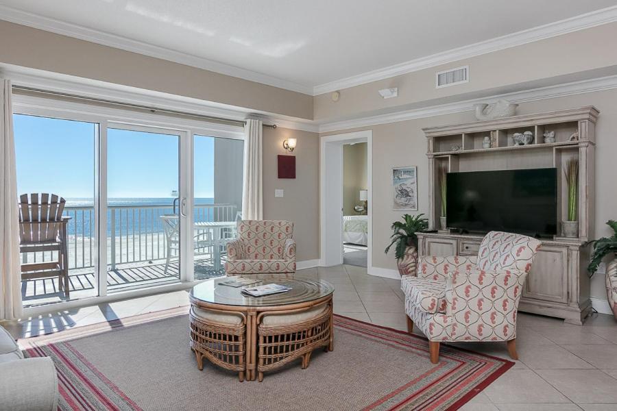 uma sala de estar com uma televisão e uma varanda em Escapes! To The Shores #204 em Orange Beach
