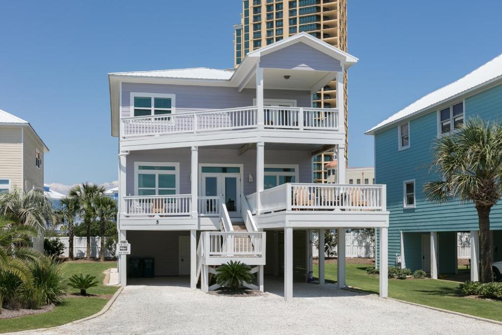 una casa con balcones blancos y un edificio azul en Serenity, en Gulf Shores