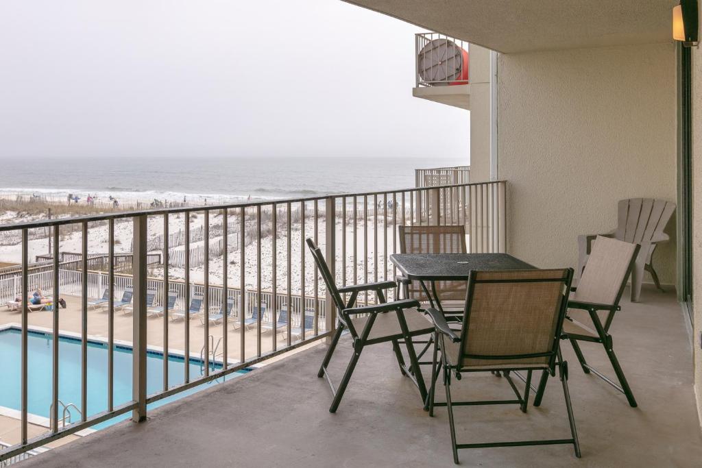 a balcony with a table and chairs and the beach at Gulf Village #215 in Gulf Shores