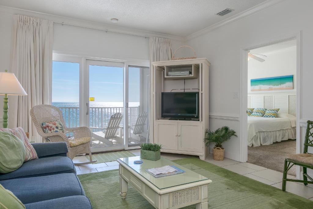 uma sala de estar com um sofá azul e uma televisão em Dolphin Key em Orange Beach