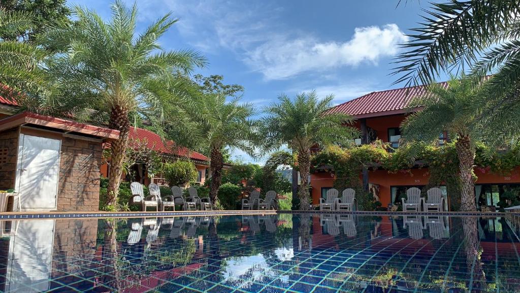 uma piscina em frente a uma casa com palmeiras em Chomview Resort em Ko Lanta