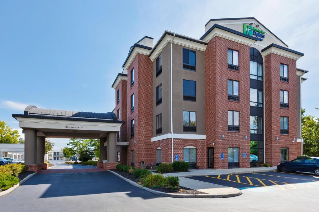 un gran edificio de ladrillo rojo con aparcamiento en Holiday Inn Express Hotel & Suites Cleveland-Richfield, an IHG Hotel, en Brecksville