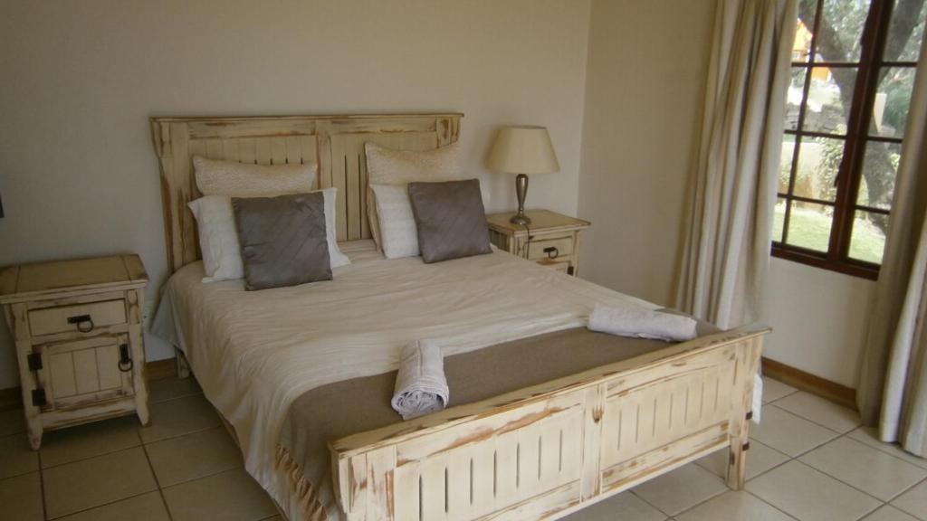 - une chambre avec un grand lit et 2 tables de chevet dans l'établissement Vila Sol - Self Catering, à Vila Praia Do Bilene