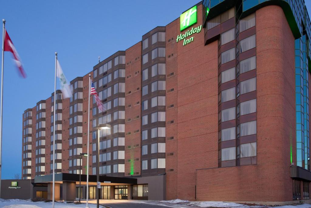 a large building with a flag on top of it at Holiday Inn Ottawa East, an IHG Hotel in Ottawa
