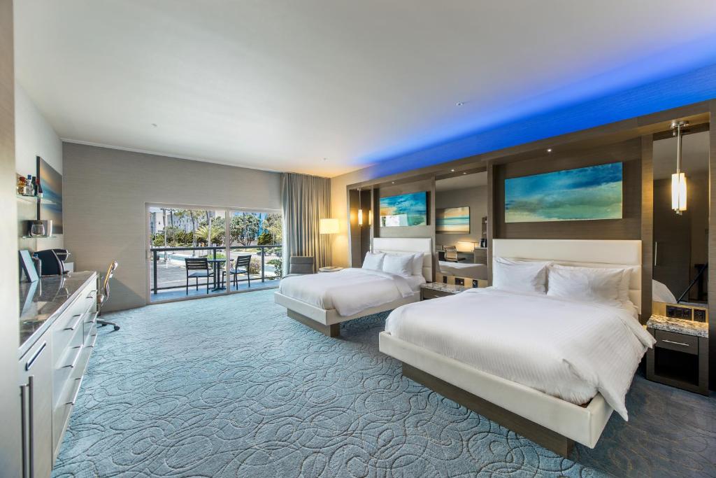 a hotel room with two beds and a balcony at Shade Hotel Redondo Beach in Redondo Beach