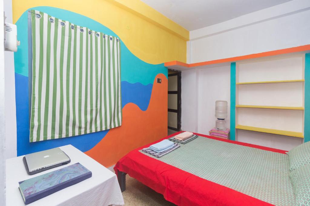 a bedroom with a bed with a colorful wall at Shaman House in Puducherry
