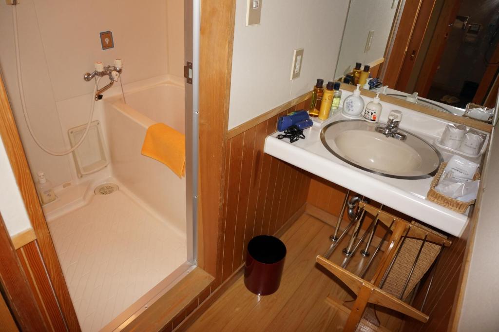 a bathroom with a sink and a shower at Wafu-no-Yado MASUYA in Yamanouchi