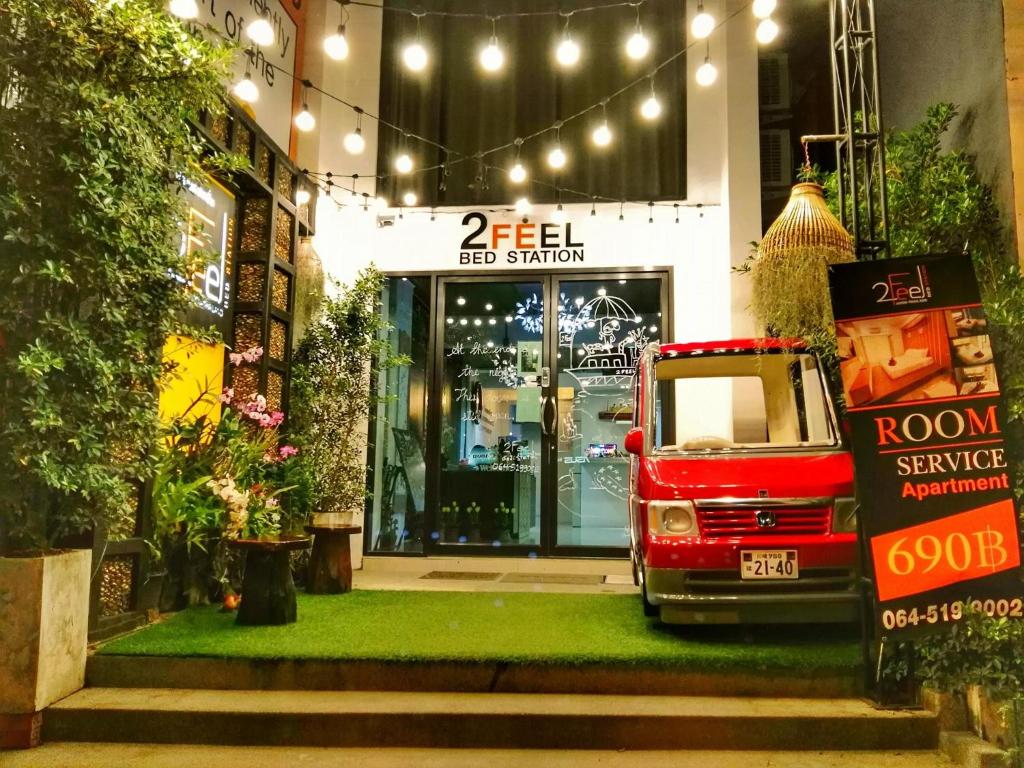 a red van parked in front of a building at 2 Feel Bed Station in Udon Thani