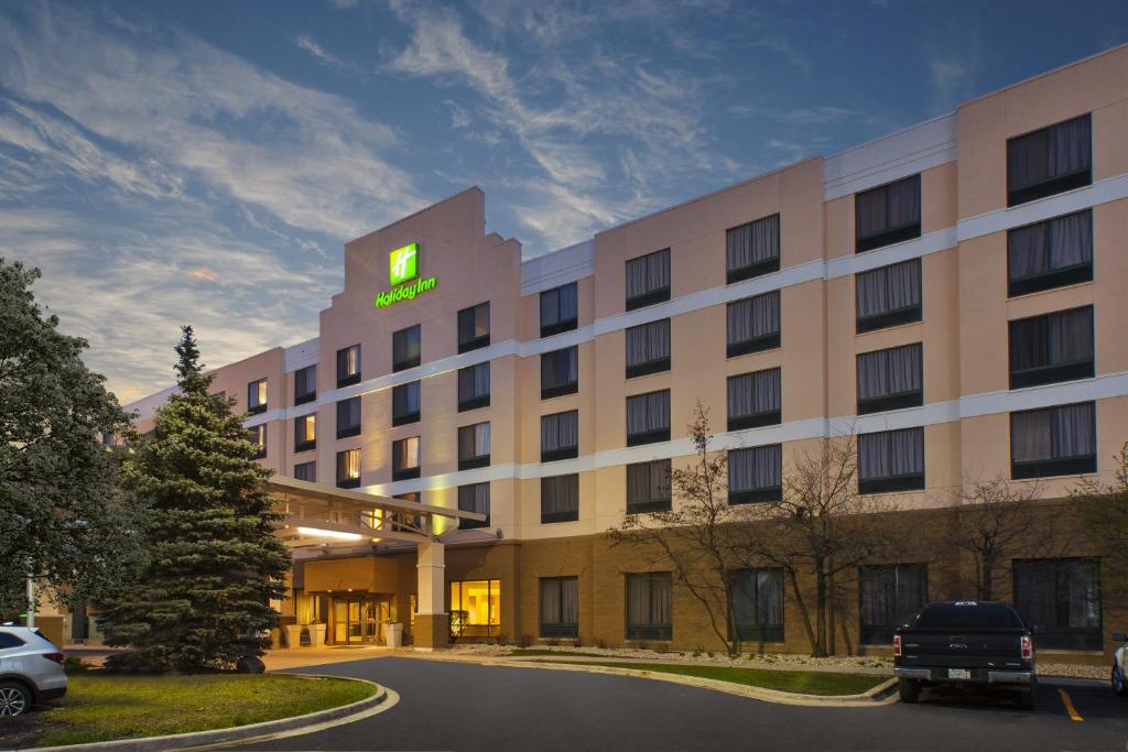 un edificio de hotel con un letrero verde. en Holiday Inn & Suites Bolingbrook, an IHG Hotel, en Bolingbrook