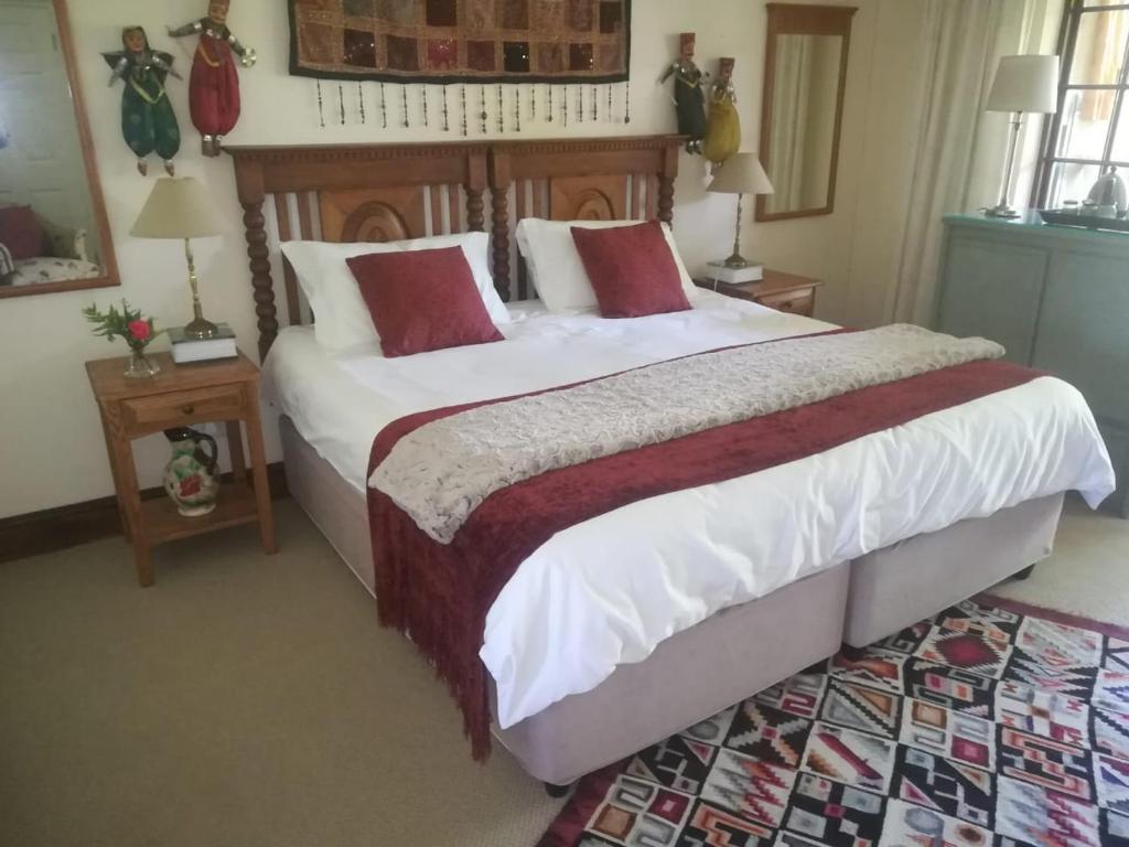 a bedroom with a large bed with red pillows at Frog Song Suite in The Crags