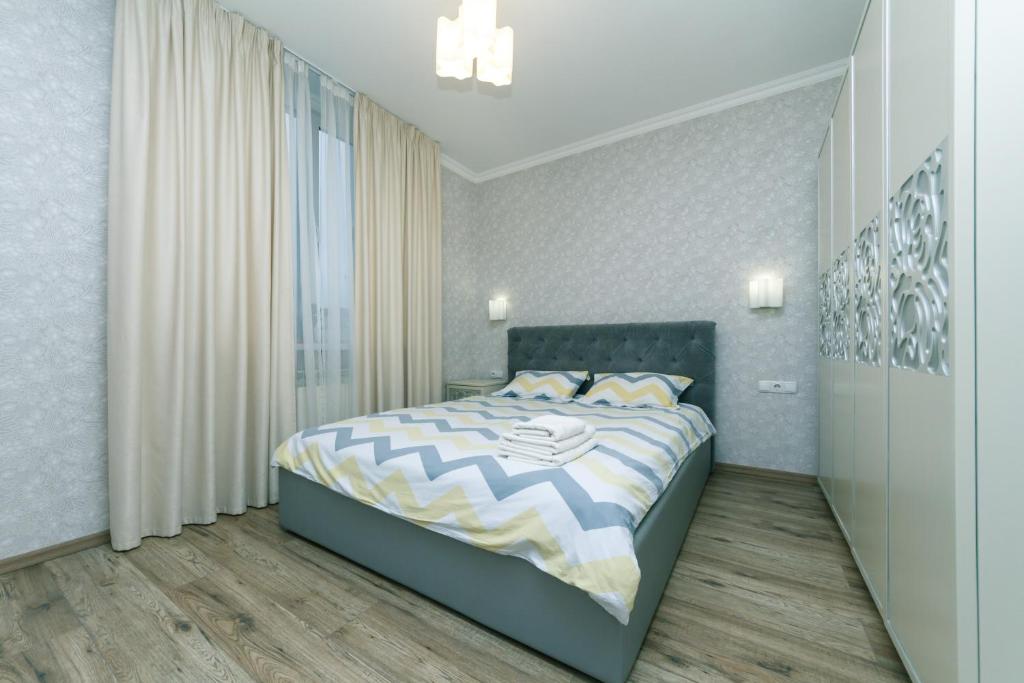 ein Schlafzimmer mit einem Bett und einem großen Fenster in der Unterkunft Лучшая квартира в Броварах in Browary