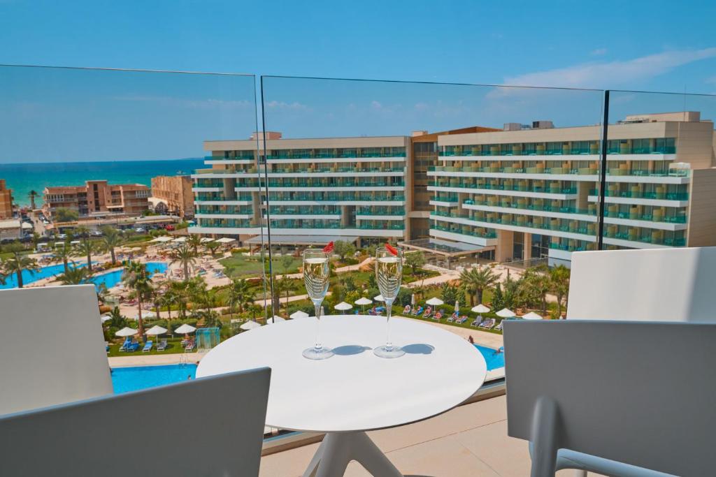 a table with two glasses of wine on a balcony at Hipotels Playa de Palma Palace&Spa in Playa de Palma