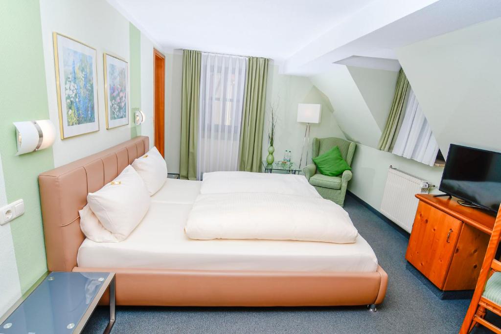 a hotel room with a bed and a tv at Gästehaus Engelgasse Herzogenaurach in Herzogenaurach