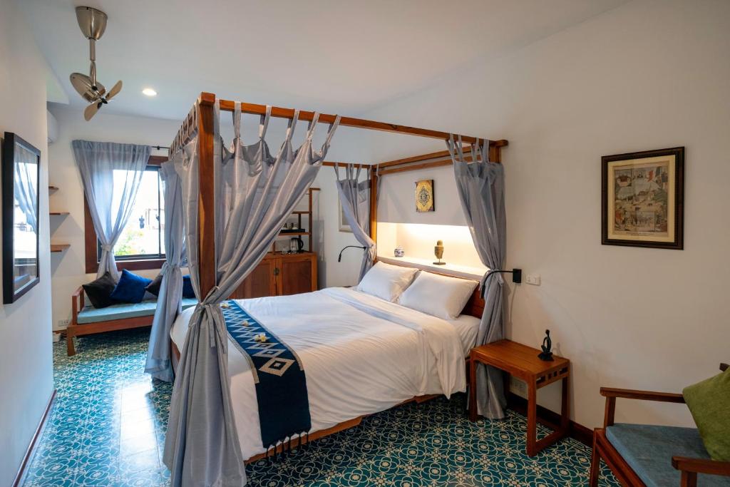 1 dormitorio con cama con dosel en una habitación en Residence Bassac, en Champasak