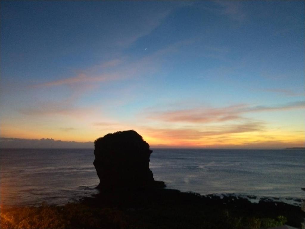 a silhouette of a person looking out over the ocean at Ming Jun Homestay in Eluan