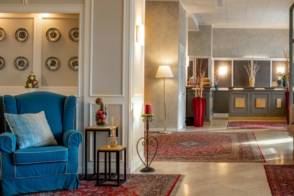 a living room filled with furniture and a clock at Hotel Ambasciatori in Brescia