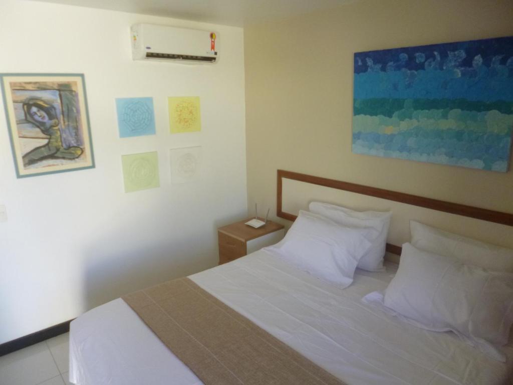 - une chambre avec un lit doté de draps et d'oreillers blancs dans l'établissement Eco Paradise ART Apt.203, à Cumbuco