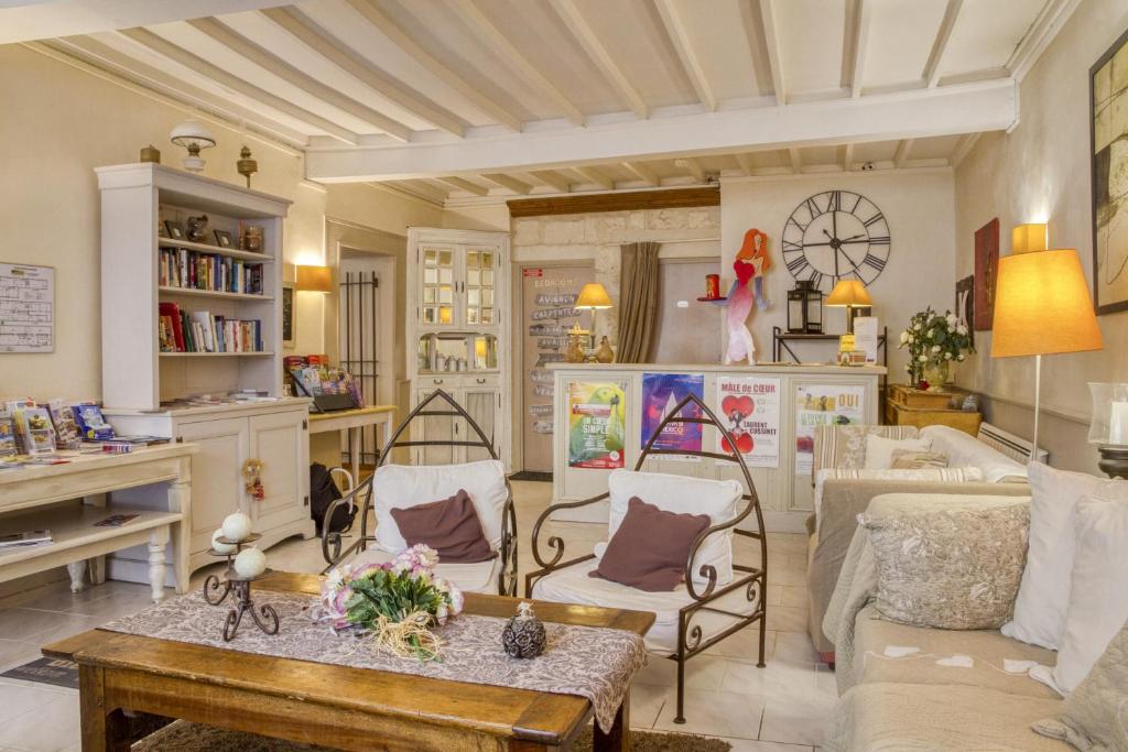 a living room filled with furniture and a table at Hotel Boquier in Avignon