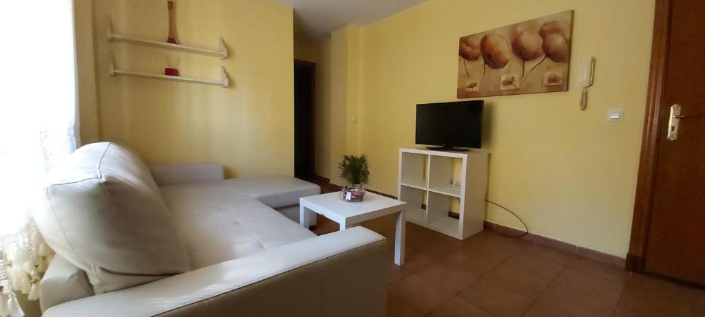 a living room with a white couch and a tv at Apartamento Cielo 35 in El Puerto de Santa María