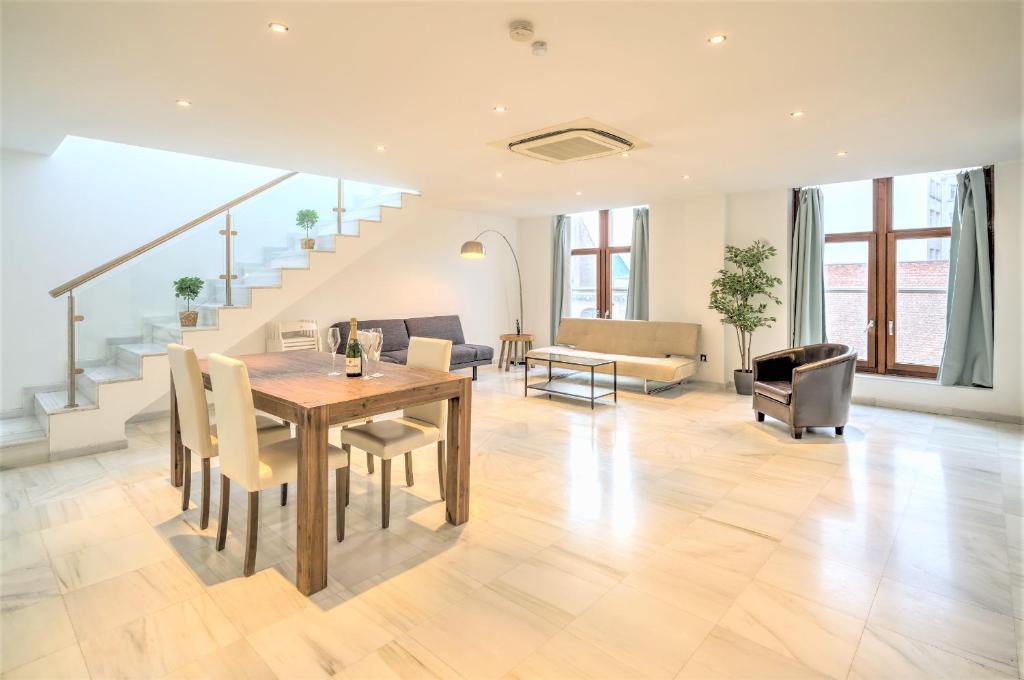 sala de estar con mesa, sillas y escaleras en Marble Lodge Apartments in the Center of Antwerp en Amberes