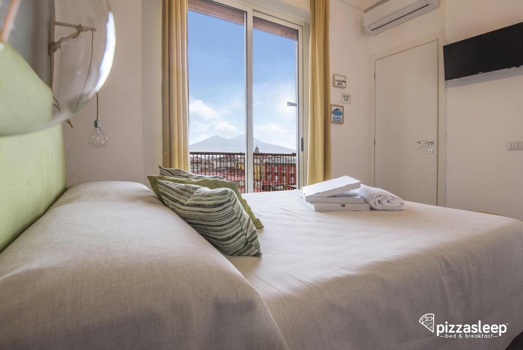 a bedroom with a large bed with a large window at PizzaSleep B&B in Naples