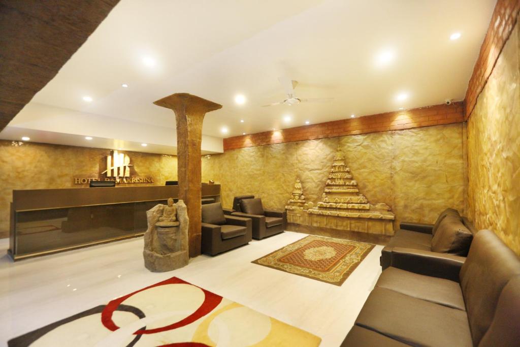 a living room with a couch and a fireplace at Hotel Ramakrishna in Mahabalipuram