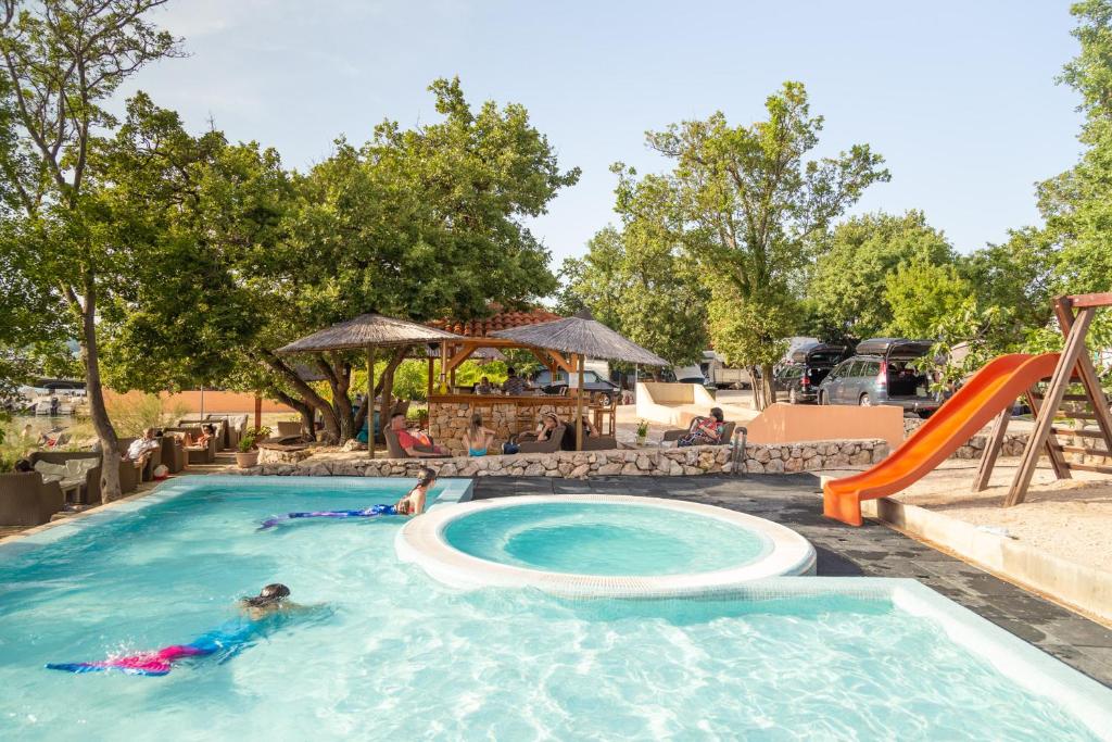 a group of people in a swimming pool at a resort at Krk Mobile Homes in Klimno