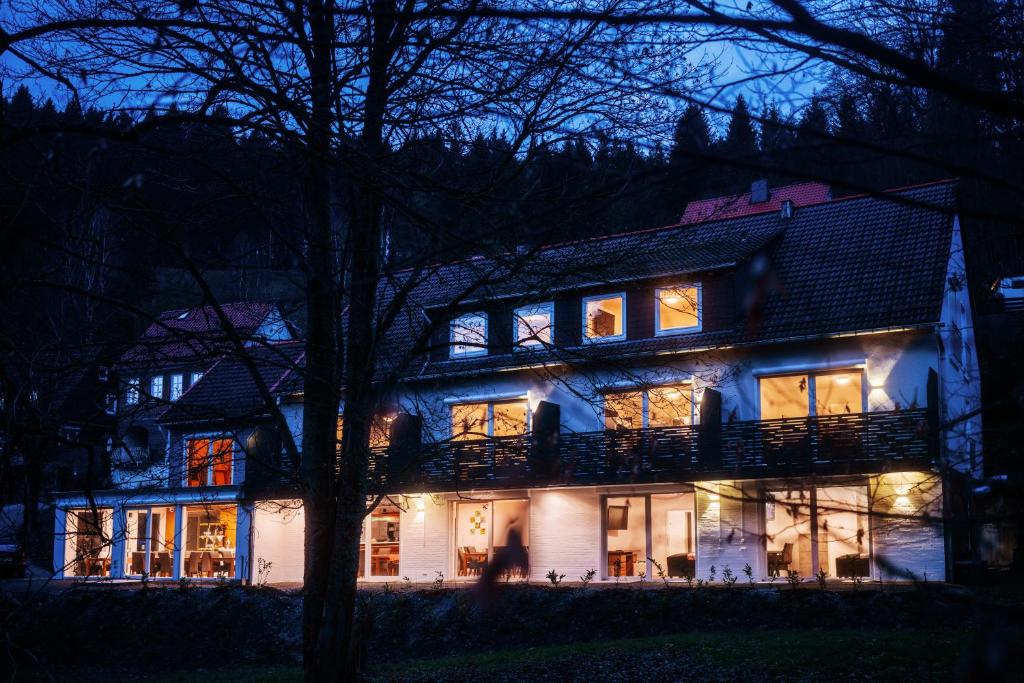 una casa grande por la noche con las luces encendidas en Hotel Hafermarkt en Wildemann