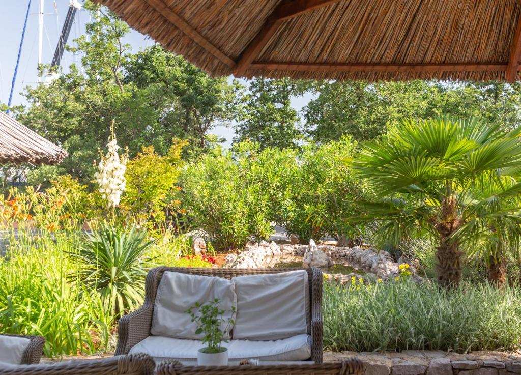 a wicker chair sitting on a patio with plants at Krk Mobile Homes in Klimno