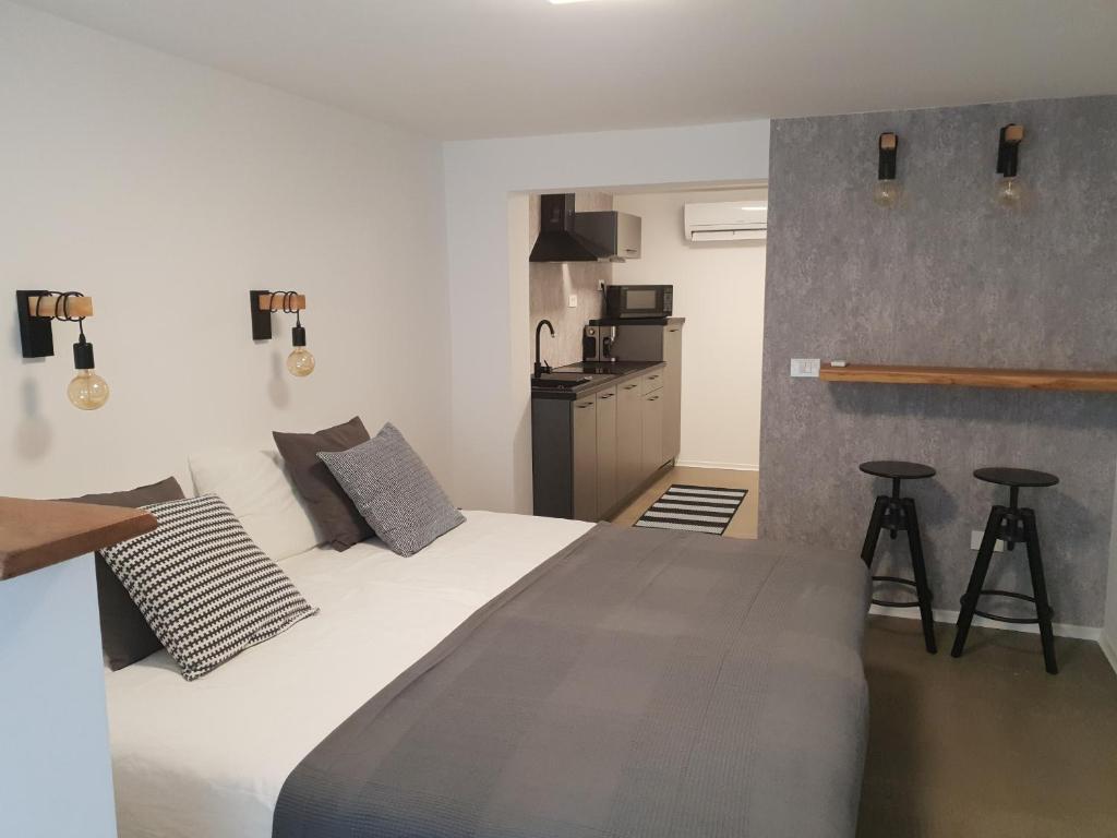 a bedroom with a large bed and a kitchen at La vita urbana in Koper