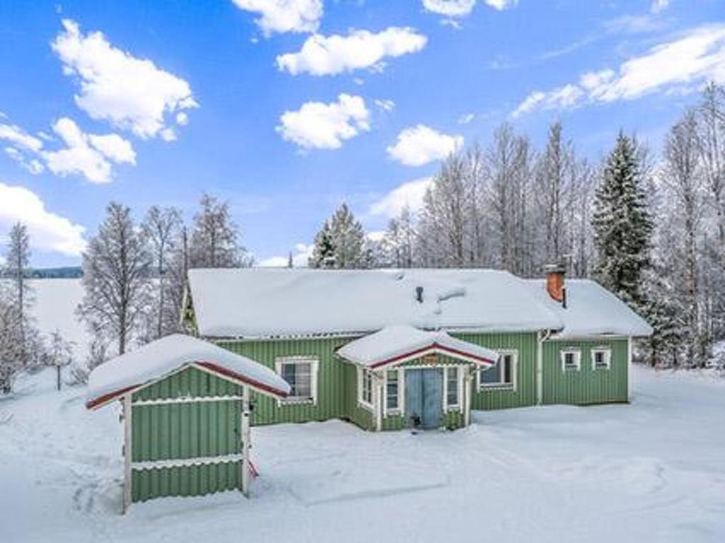 uma casa verde com neve em cima em Holiday Home Lehto by Interhome em Jokijärvi