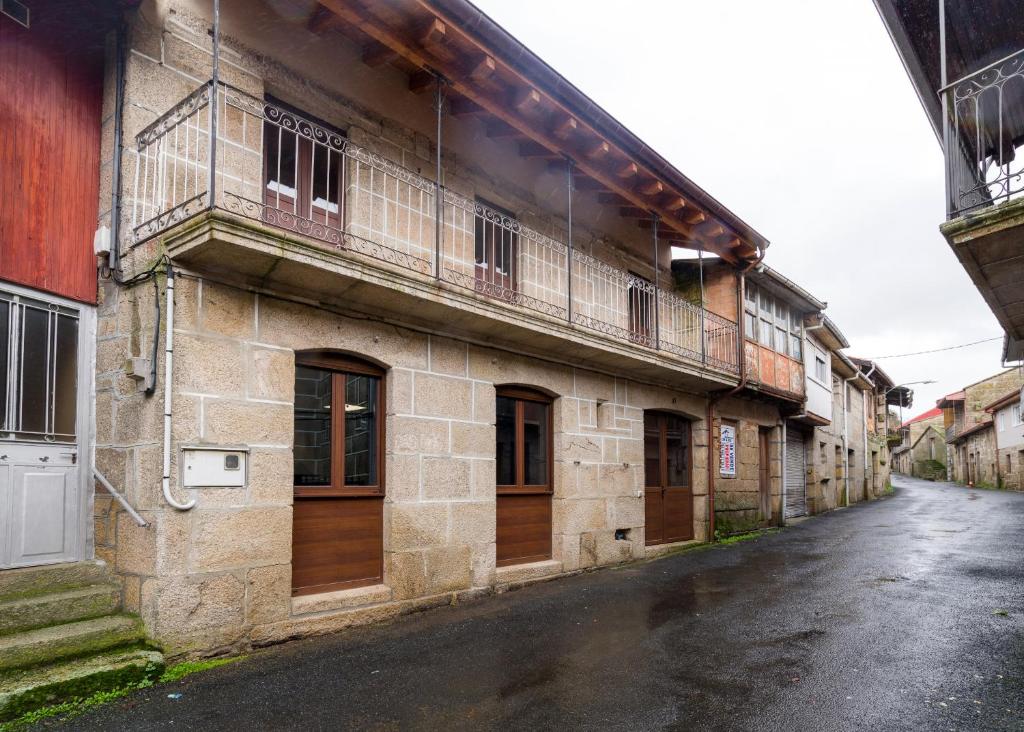 an old building with wooden doors on a street at Gran Casa Rural A Touza in Ourense