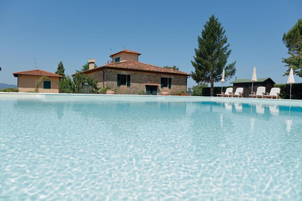 a large swimming pool with a house in the background at Podere I Sorbi in San Donato in Fronzano