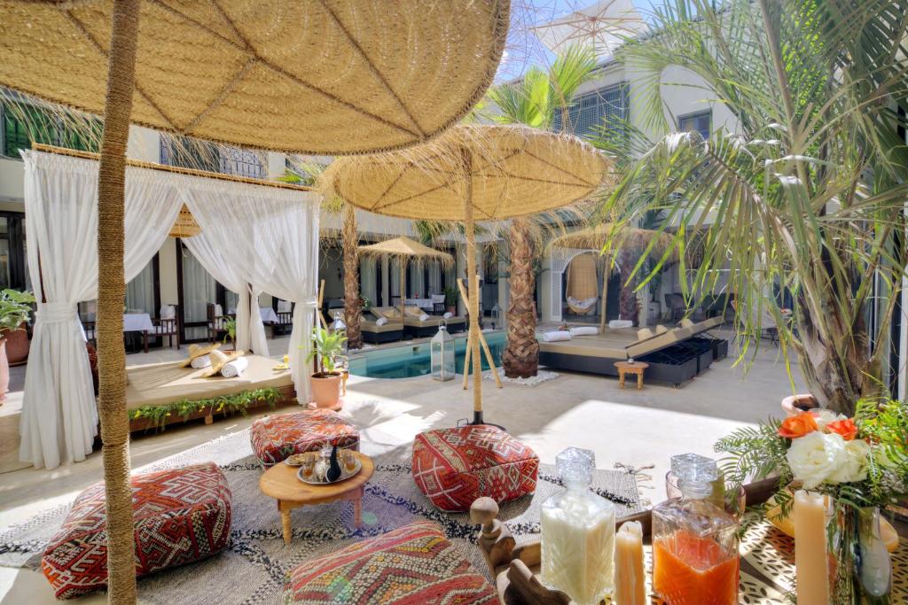 um resort com uma piscina e um pátio com guarda-sóis em Riad Saranda Hotel Restaurant & Spa em Marrakech