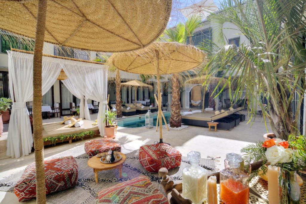 a resort with a pool and a patio with umbrellas at Riad Saranda Hotel Restaurant & Spa in Marrakesh