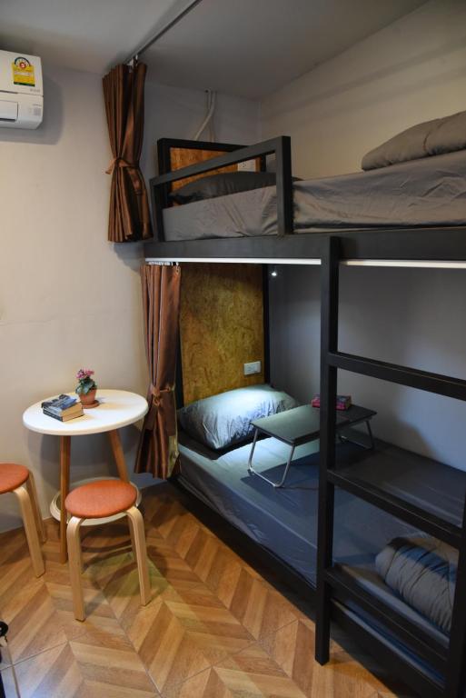 a room with two bunk beds and a table at Zleepingpills Aonang Krabi in Krabi town