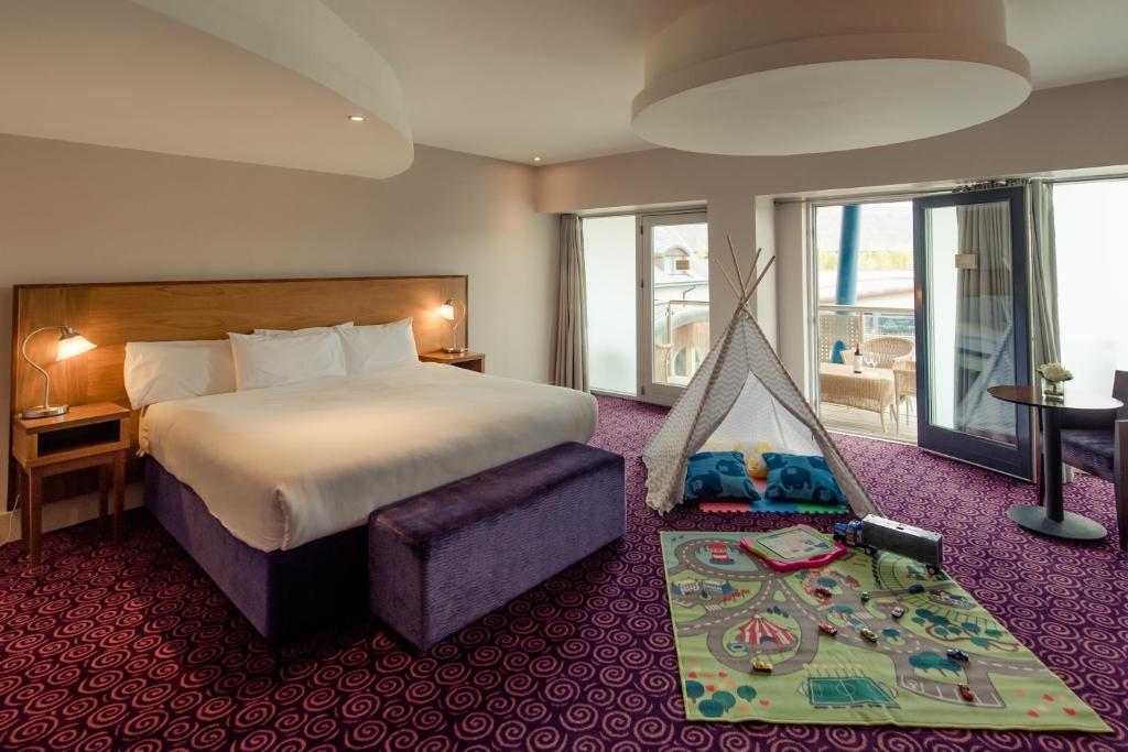 a hotel room with a bed and a hammock in it at Osprey Hotel in Naas
