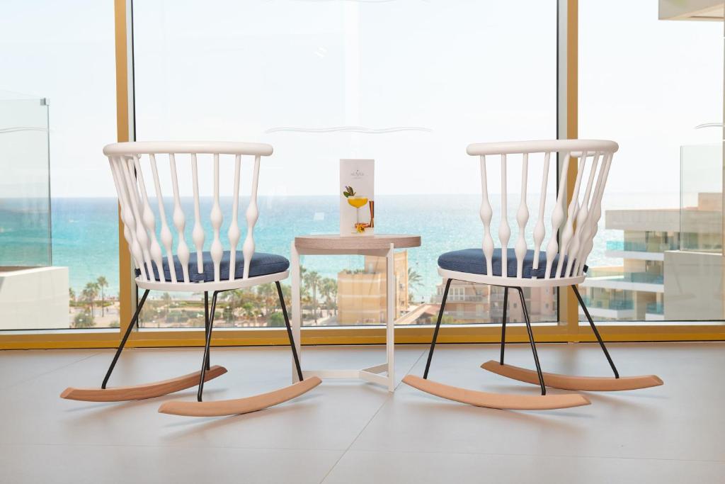 two chairs sitting in front of a window with the ocean at Hipotels Playa de Palma Palace&Spa in Playa de Palma