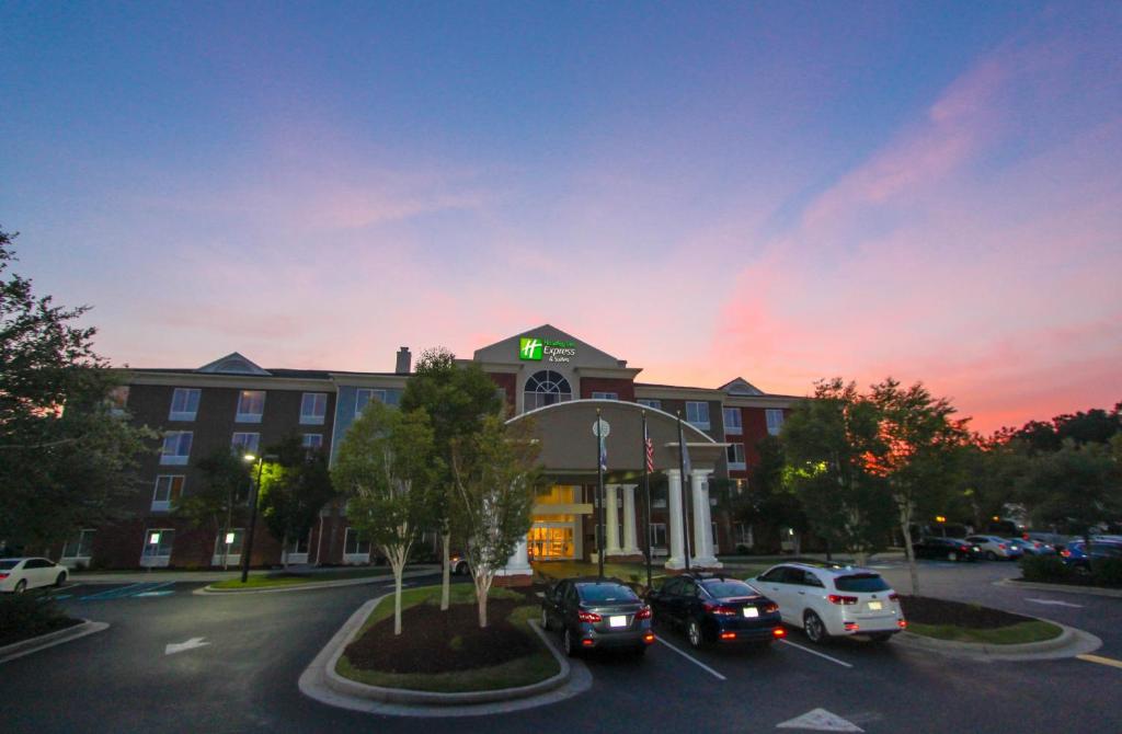 un edificio con coches estacionados en un estacionamiento en Holiday Inn Express Hotel & Suites Charleston - North, an IHG Hotel, en Charleston